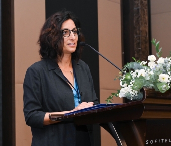 Michelle Moghadassi speaking at a podium during the workshop in Thailand.