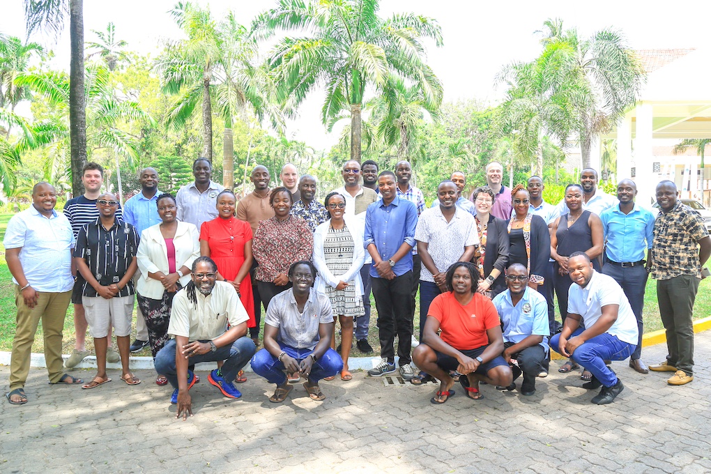 OpenMRS OPD Convergence Workshop participants standing outside in front of palm trees Mombasa, Kenya